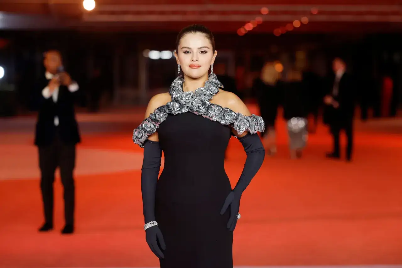 Selena Gomez stuns in a black off-the-shoulder gown with a sparkling floral collar and long gloves.