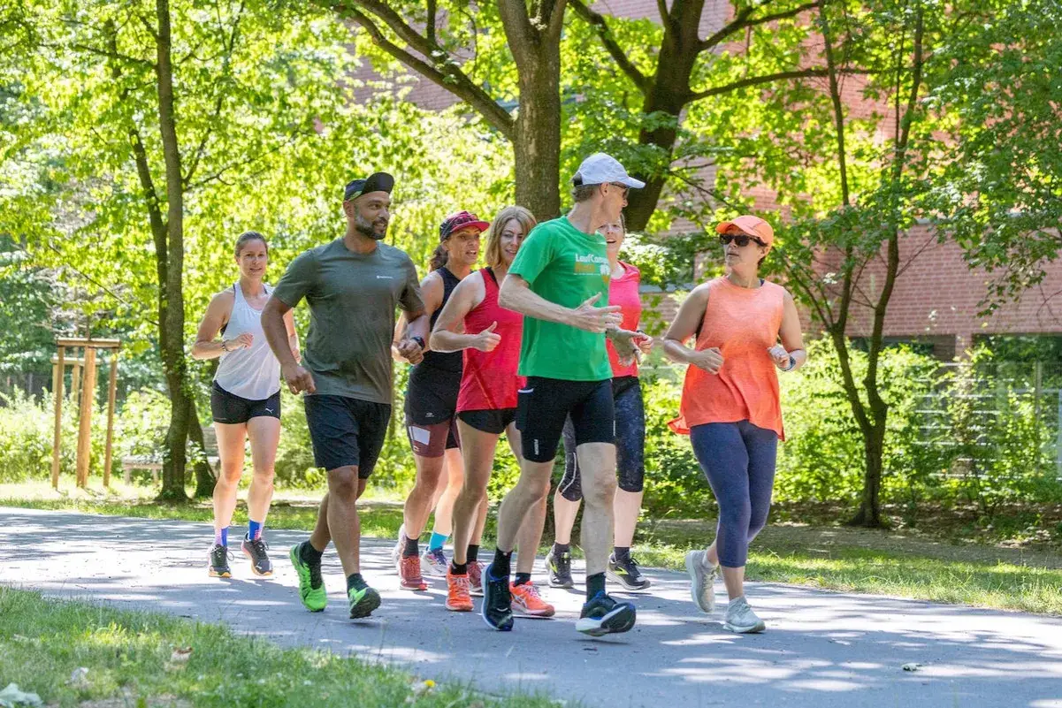 Eine Gruppe von L&auml;ufern genie&szlig;t eine sonnige Auszeit bei ihren laufgruppen berlin.