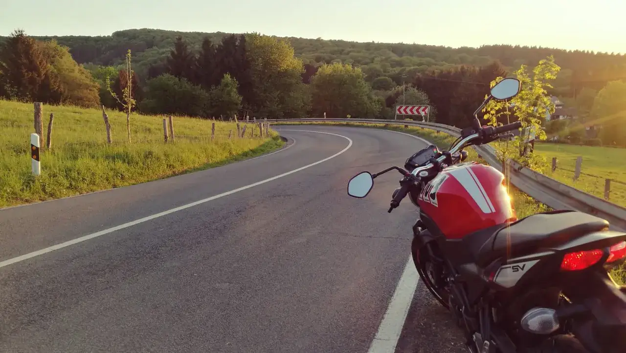 Rotes Motorrad am Stra&szlig;enrand im Bergischen Land. Perfekt f&uuml;r eine Motorradtour durch die h&uuml;gelige Landschaft.