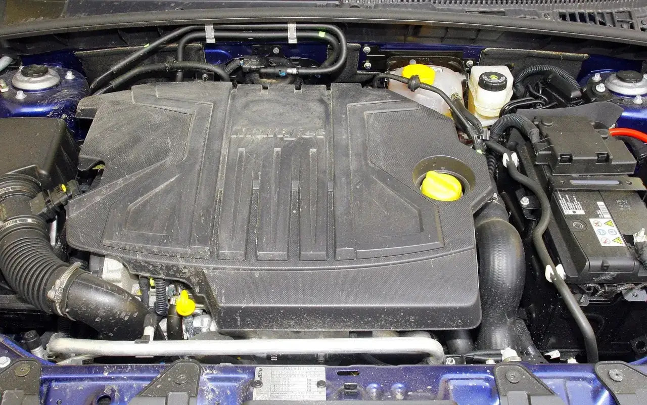 Silnik MultiJet w Fiat Croma 1.9 JTD. Widoczny czarny plastikowy wlot powietrza, akumulator i zbiorniczek płynu hamulcowego.