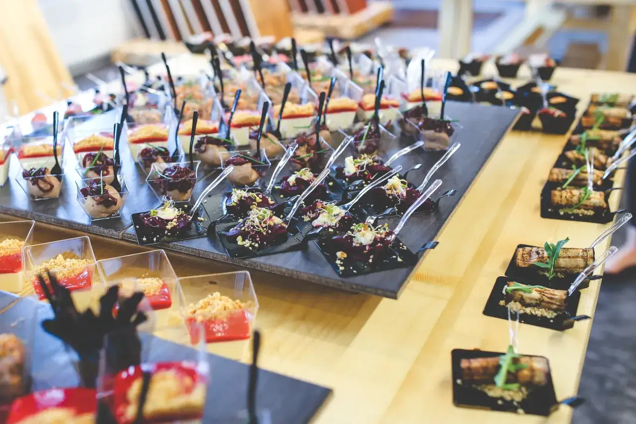 Elegancki catering na konferencje: mini desery i wytrawne przekąski w eleganckich naczyniach, gotowe do degustacji.