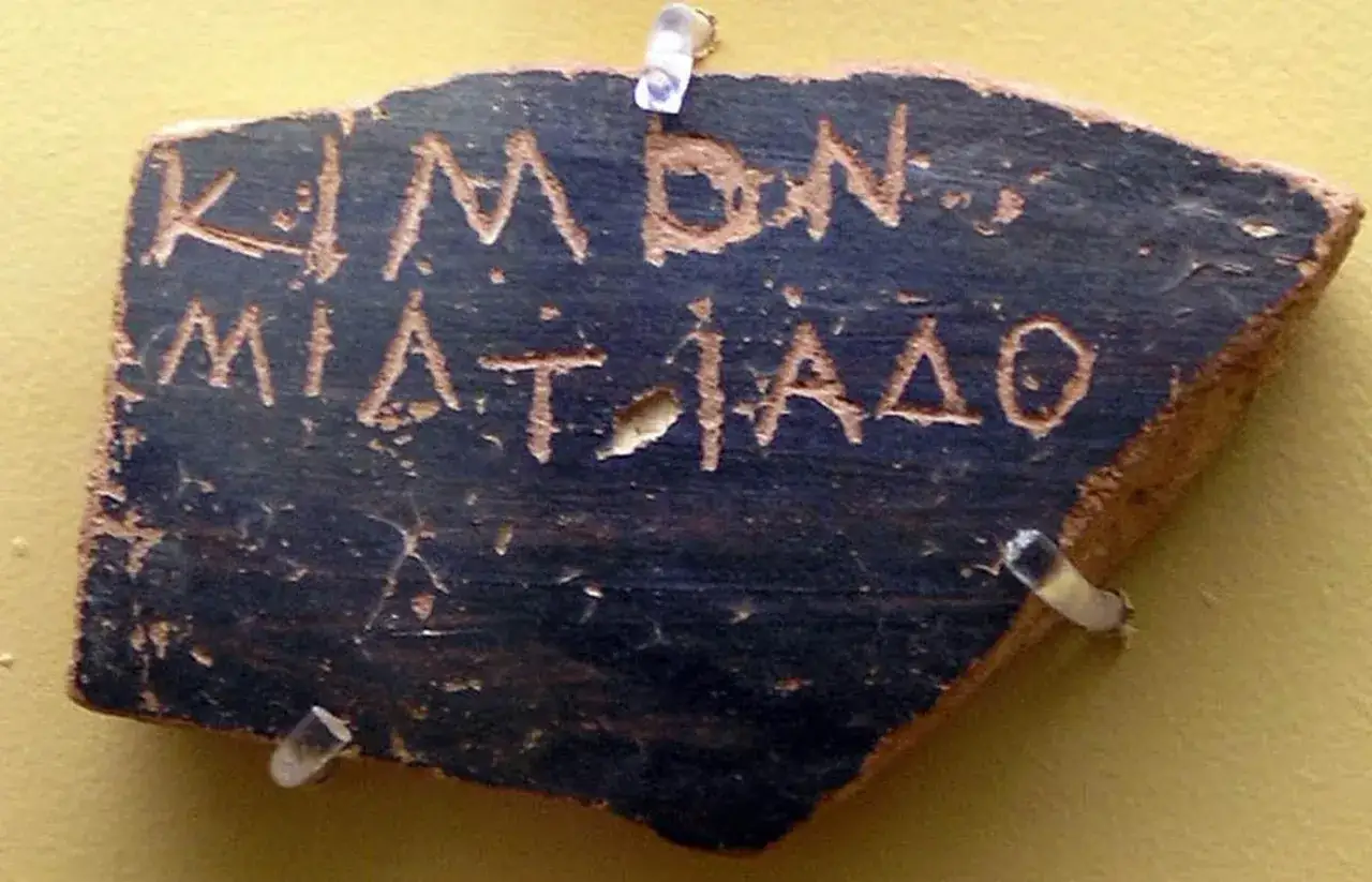 Fragment ceramiki z greckim napisem. To przykład ostracyzm co to, czyli głosowania nad wygnaniem obywatela.