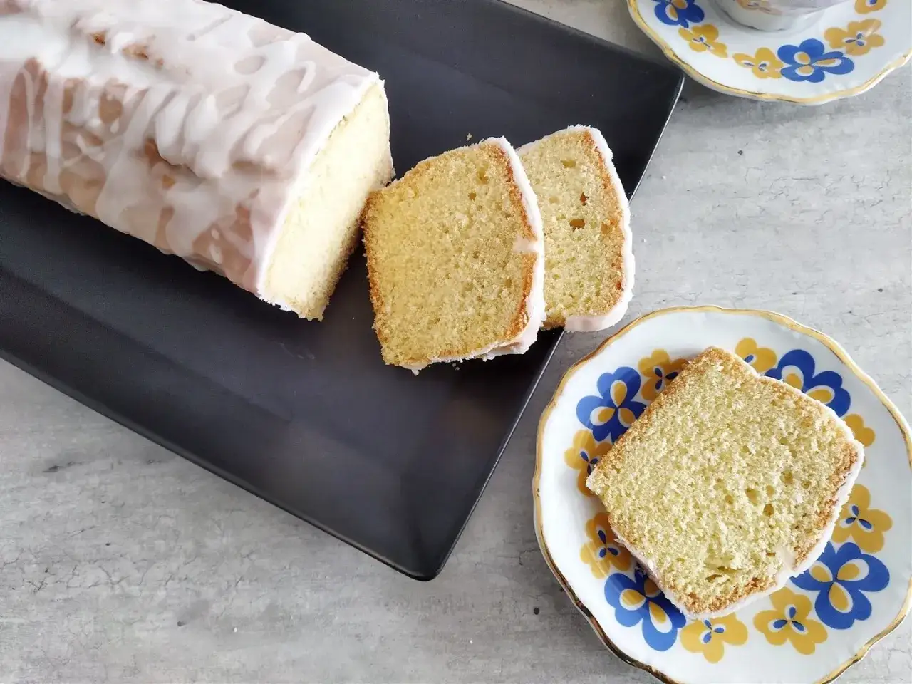 Pyszna babka piaskowa z lukrem, pokrojona na kawałki, czeka na talerzyku.