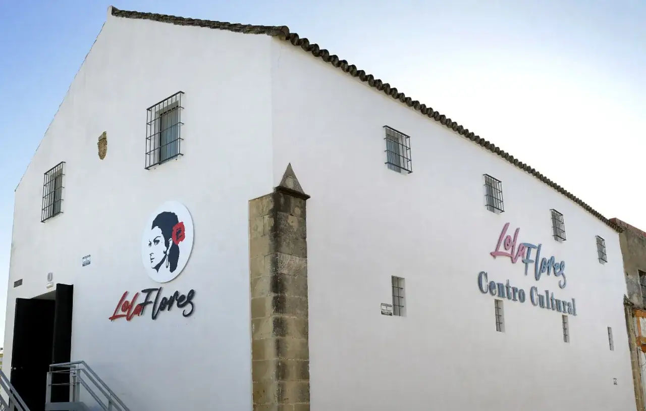 Centro Cultural Lola Flores, un edificio blanco con ventanas enrejadas y un retrato de la artista.