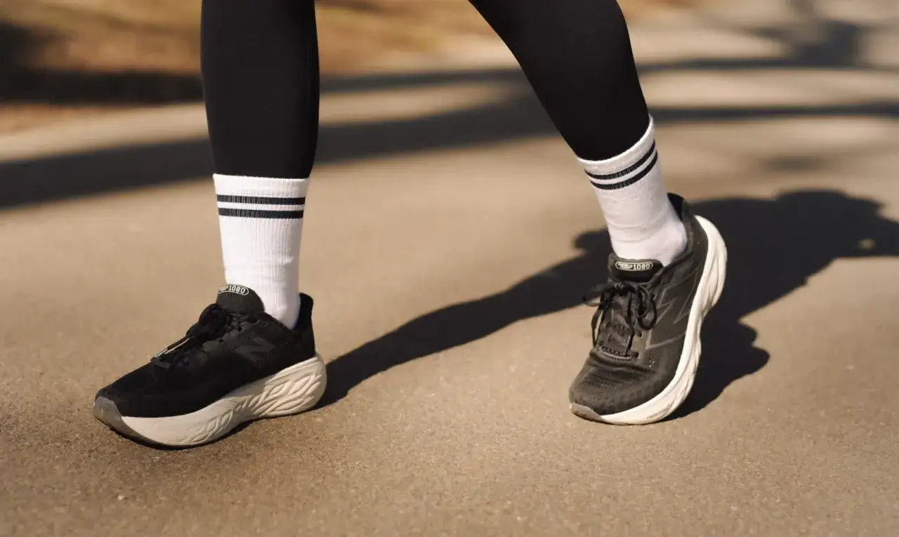Czarne buty do maratonu z białymi skarpetkami w paski, gotowe na długi bieg.