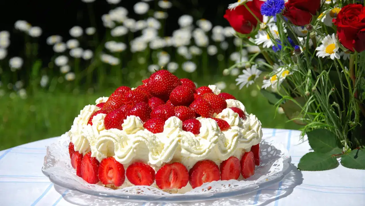 En vacker jordgubbst&aring;rta med vispgr&auml;dde och f&auml;rska jordgubbar, perfekt f&ouml;r ett sommarfika. Ett enkelt t&aring;rta recept att prova!
