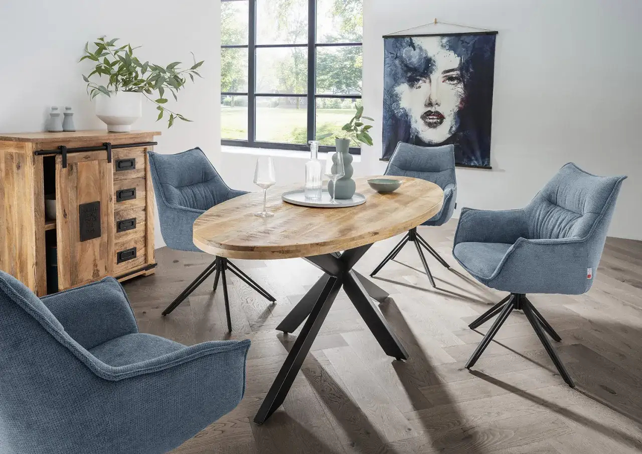 Modernes wohnzimmer: graue Sessel um einen ovalen Holztisch, daneben ein rustikales Sideboard.