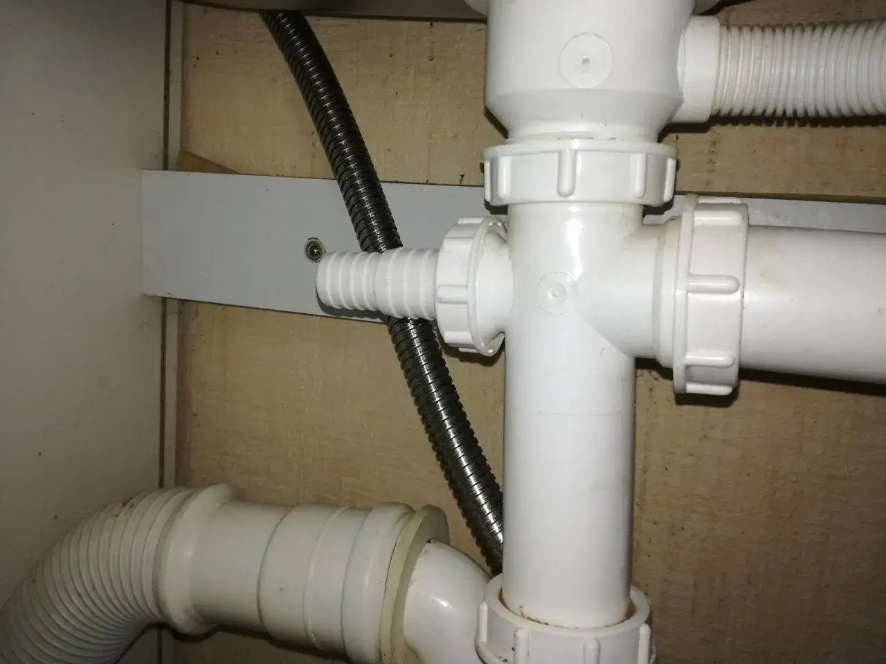 Trójnik do zmywarki i kranu podłączony do syfonu. Wąż odpływowy zmywarki połączony z instalacją.