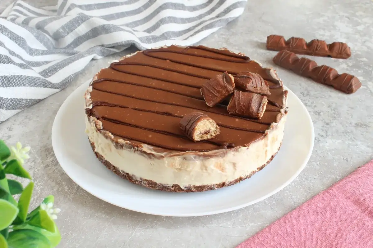 Cheesecake Kinder Bueno con copertura al cioccolato e pezzi di wafer croccante.