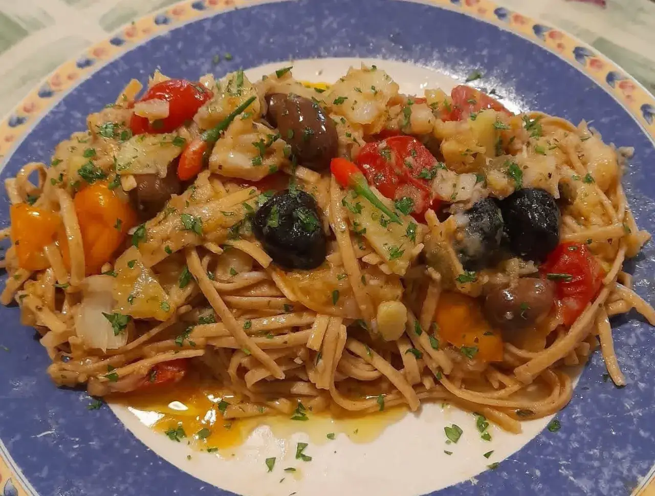 Pasta integrale con pesce, pomodorini, olive e peperoni: un sapore autentico di mangiare calabrese.