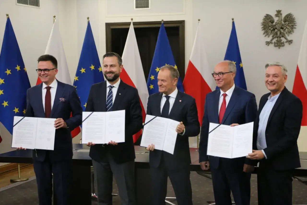 Pięciu mężczyzn w garniturach trzyma dokumenty. To tekst umowy koalicyjnej, symbol porozumienia.
