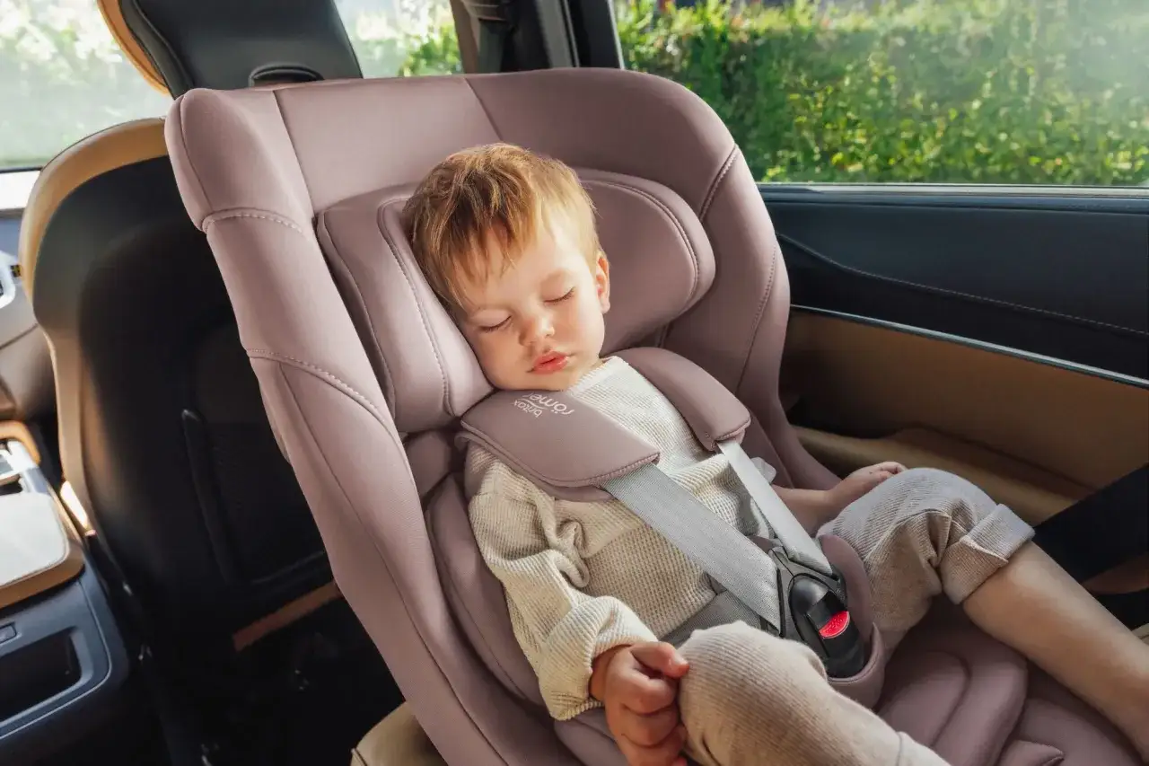 Kleines Kind schl&auml;ft in rosafarbener Babyschale im Auto. Ab wann Sitzschale bei Kindern? Diese Babyschale ist ideal f&uuml;r die Kleinsten.