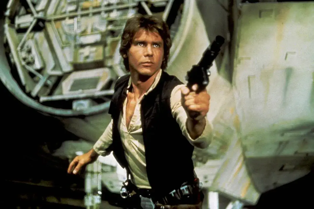 Han Solo, grany przez Harrisona Forda (którego wiek w tym momencie to 39 lat), z blasterem w dłoni, gotowy do akcji na pokładzie Sokoła Millennium.