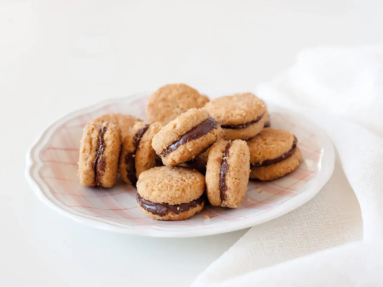 Un piatto pieno di deliziosi baci di dama, biscotti friabili con un cuore di cioccolato fondente.