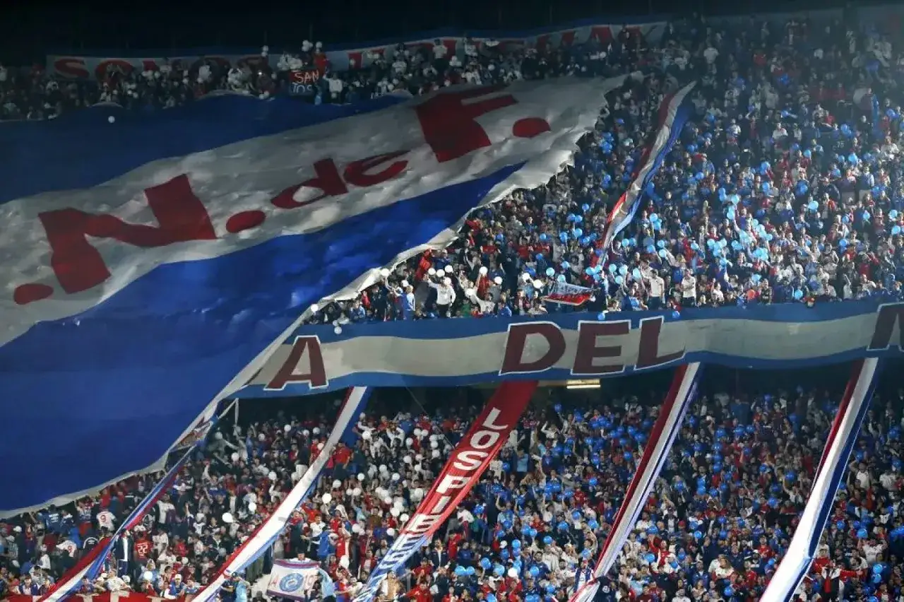 Tysiące kibiców na stadionie, wielka flaga z napisem 
