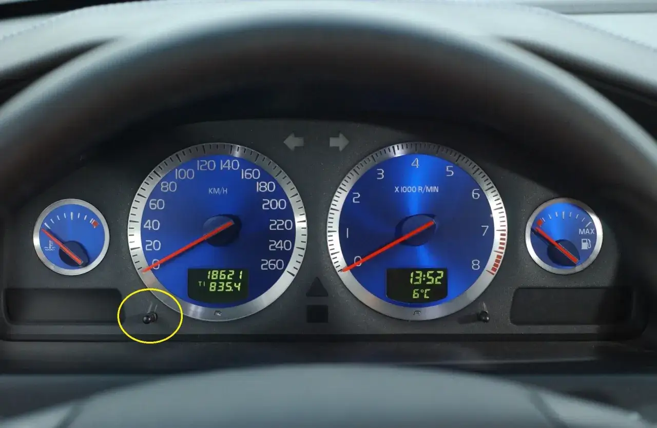 Wskaźniki Volvo S60, w tym prędkościomierz i obrotomierz, z widocznym przyciskiem do kasowania inspekcji.