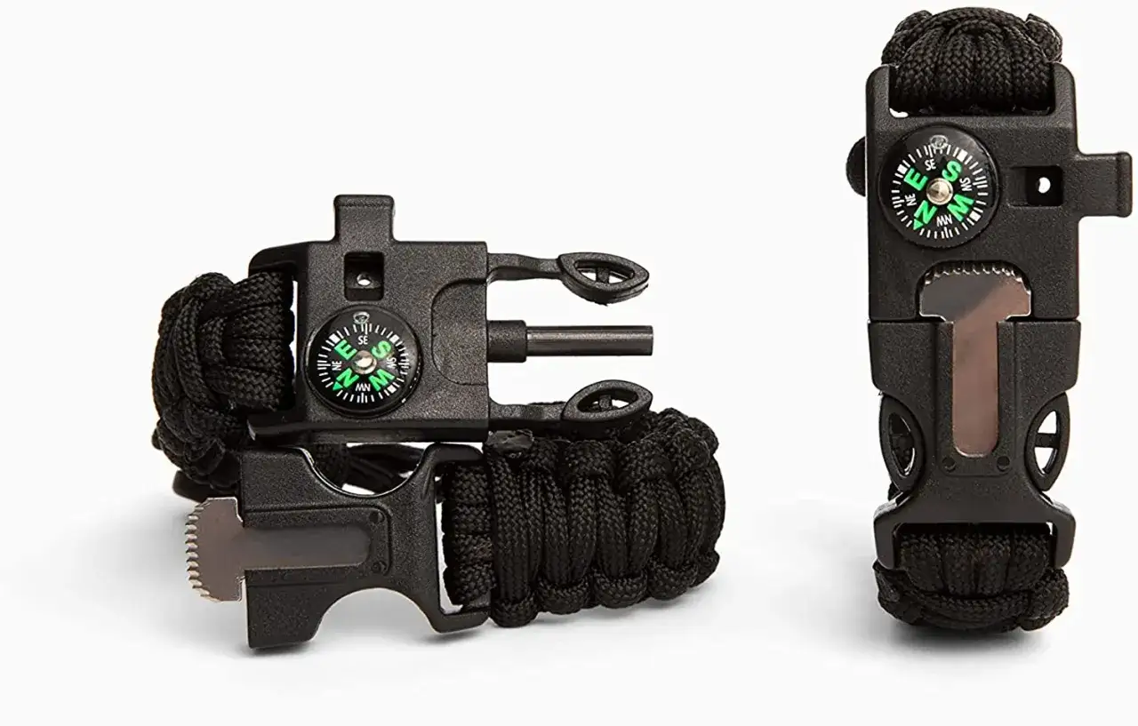 Pulsera de supervivencia negra con br&uacute;jula y pedernal. Un **cord&oacute;n silbato** listo para la aventura.