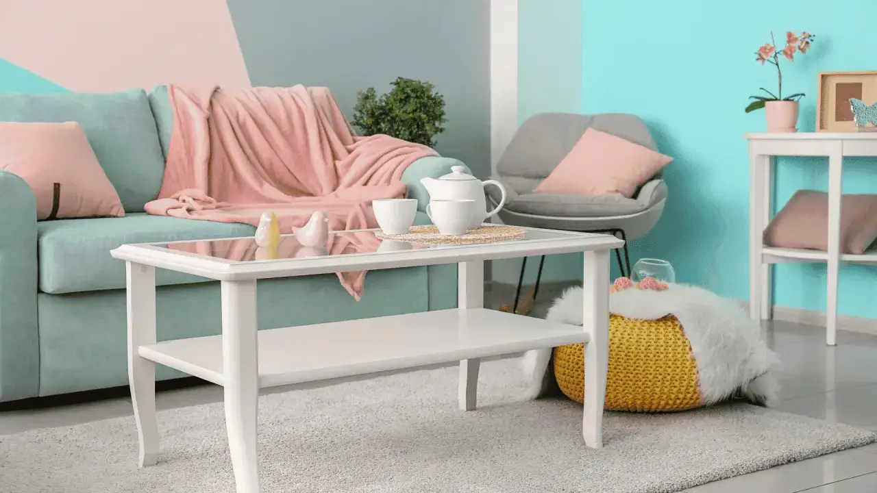 Gemütliches Wohnzimmer im **danish pastel** Stil mit mintgrünem Sofa, rosa Decke, Kaffeegeschirr und gelbem Pouf.