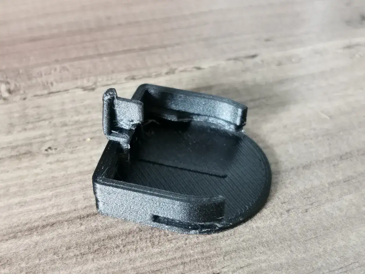 Support badge Ulys, un petit objet noir imprim&eacute; en 3D, pr&ecirc;t &agrave; &ecirc;tre fix&eacute;.