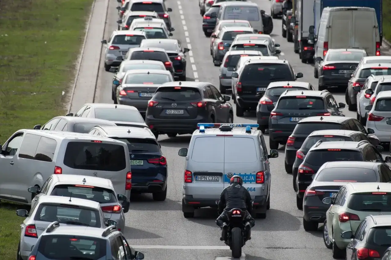 Korki na drodze ekspresowej. Czy można cofać na drodze ekspresowej? Policja i motocyklista w tłumie samochodów.