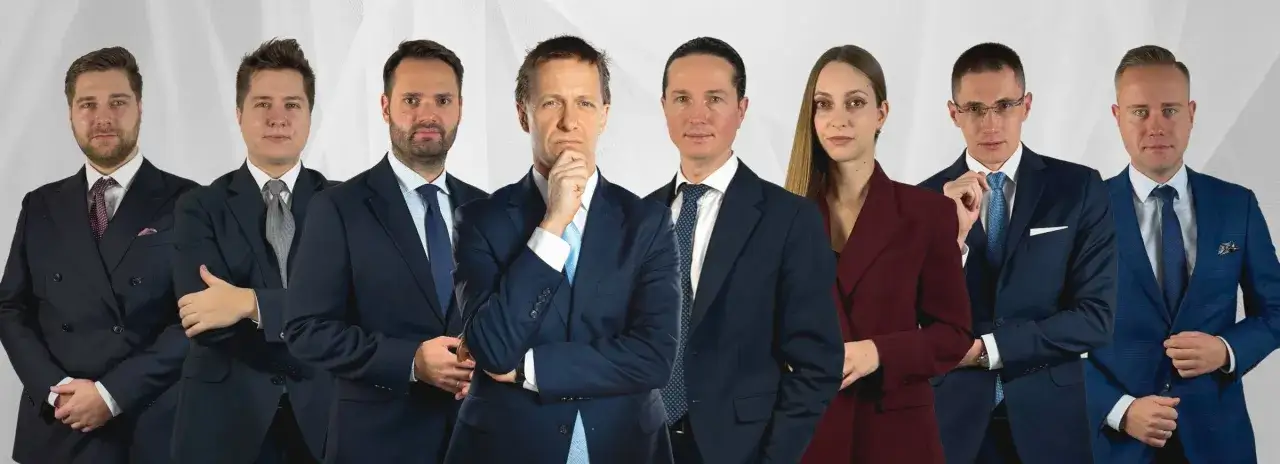 Grupa prawników w garniturach na jasnym tle.