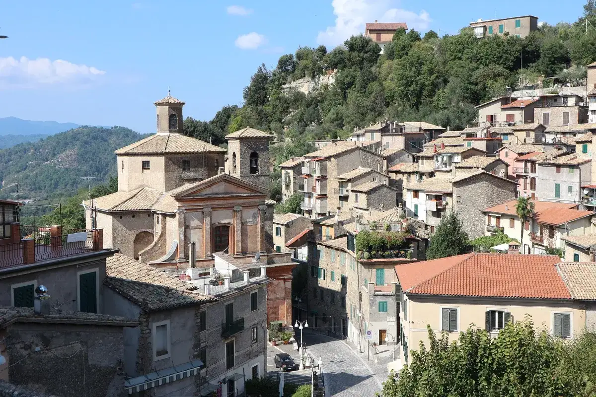 Un panorama del **subiaco centro storico** con chiese, case in pietra e tetti rossi, immerso nel verde delle colline.