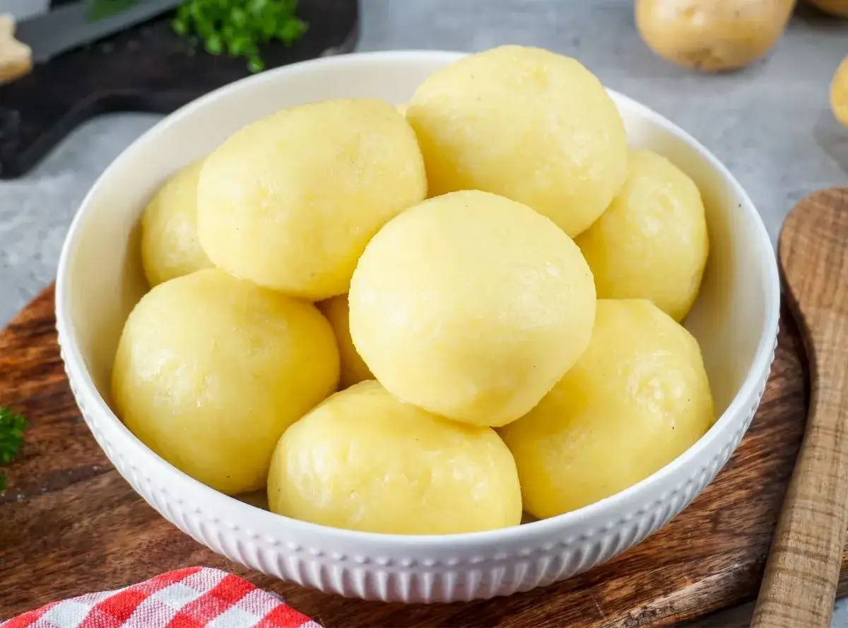 Schüssel voller goldgelber Kartoffelklöße, ein Genuss für jedes Kartoffel-Restaurant.