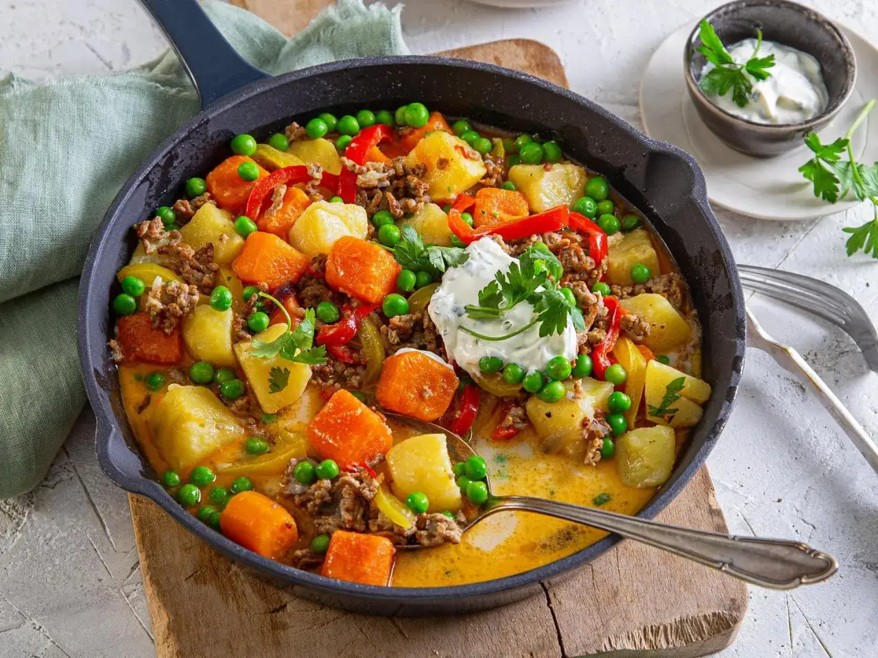 Herzhaftes Gericht aus Hackfleisch, Kartoffeln, Erbsen und Paprika in einer cremigen Sauce, perfekt f&uuml;r ein schnelles erbsen rezept. Garniert mit frischer Petersilie und einem Klecks Sour Cream.
