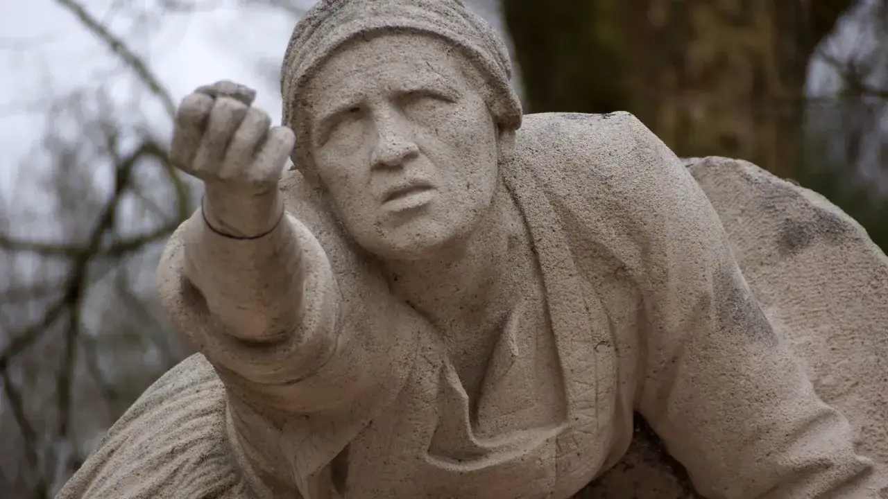 Sculpture d'une femme en d&eacute;tresse, &eacute;voquant la liste des morts pour la France 39-45 par commune. Son regard implore, sa main tendue vers l'aide.