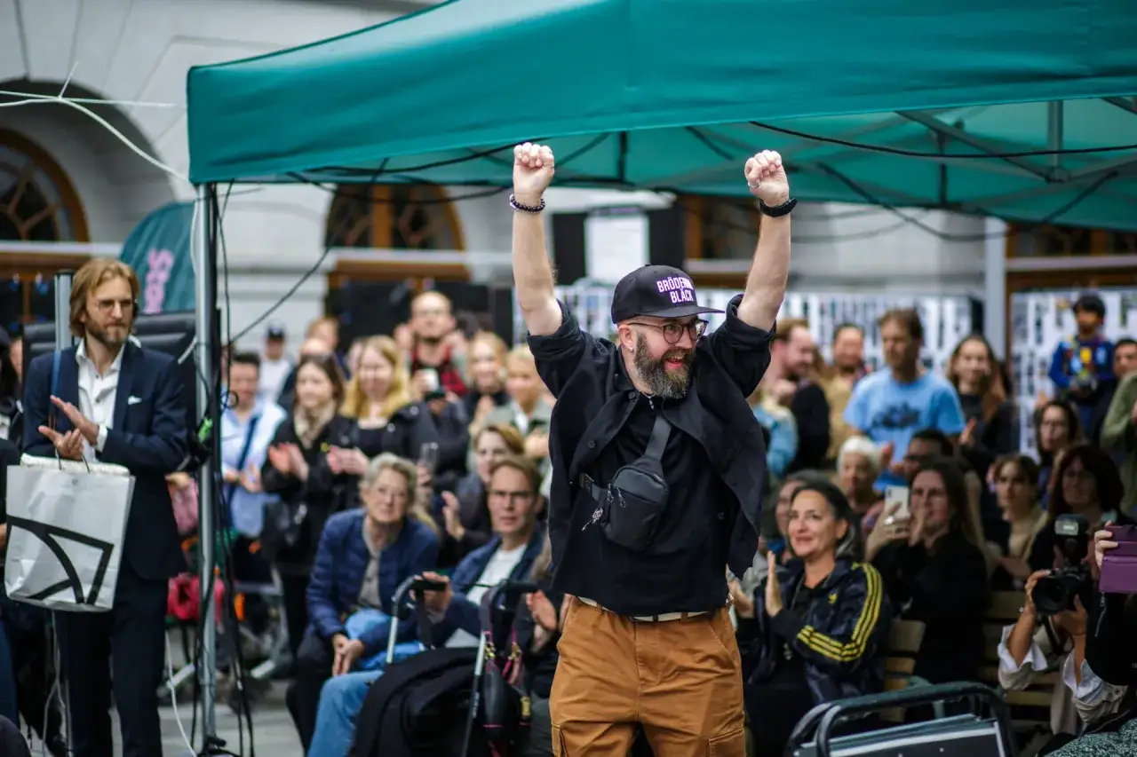 Glad deltagare med uppsträckta armar under stockholm fotomaraton.
