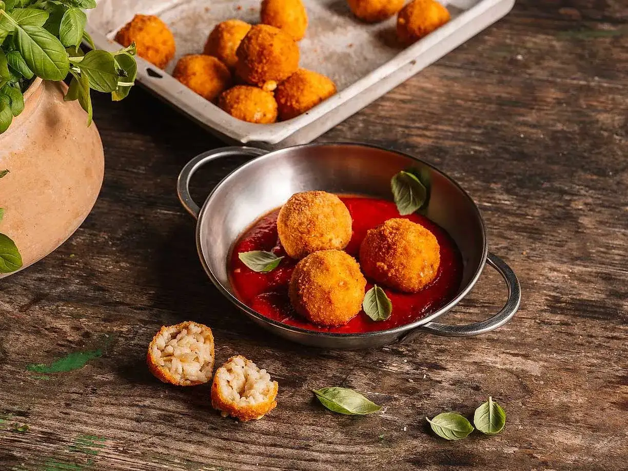 Krispiga arancini med en smakrik tomatsås. Ett perfekt arancini recept för en härlig måltid.