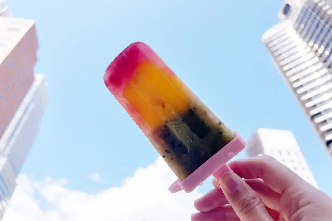 Bunte Frucht-Eissorte, perfekt zum Wassereis selber machen. Ein Genuss im Sommer vor der Kulisse von Hochh&auml;usern.