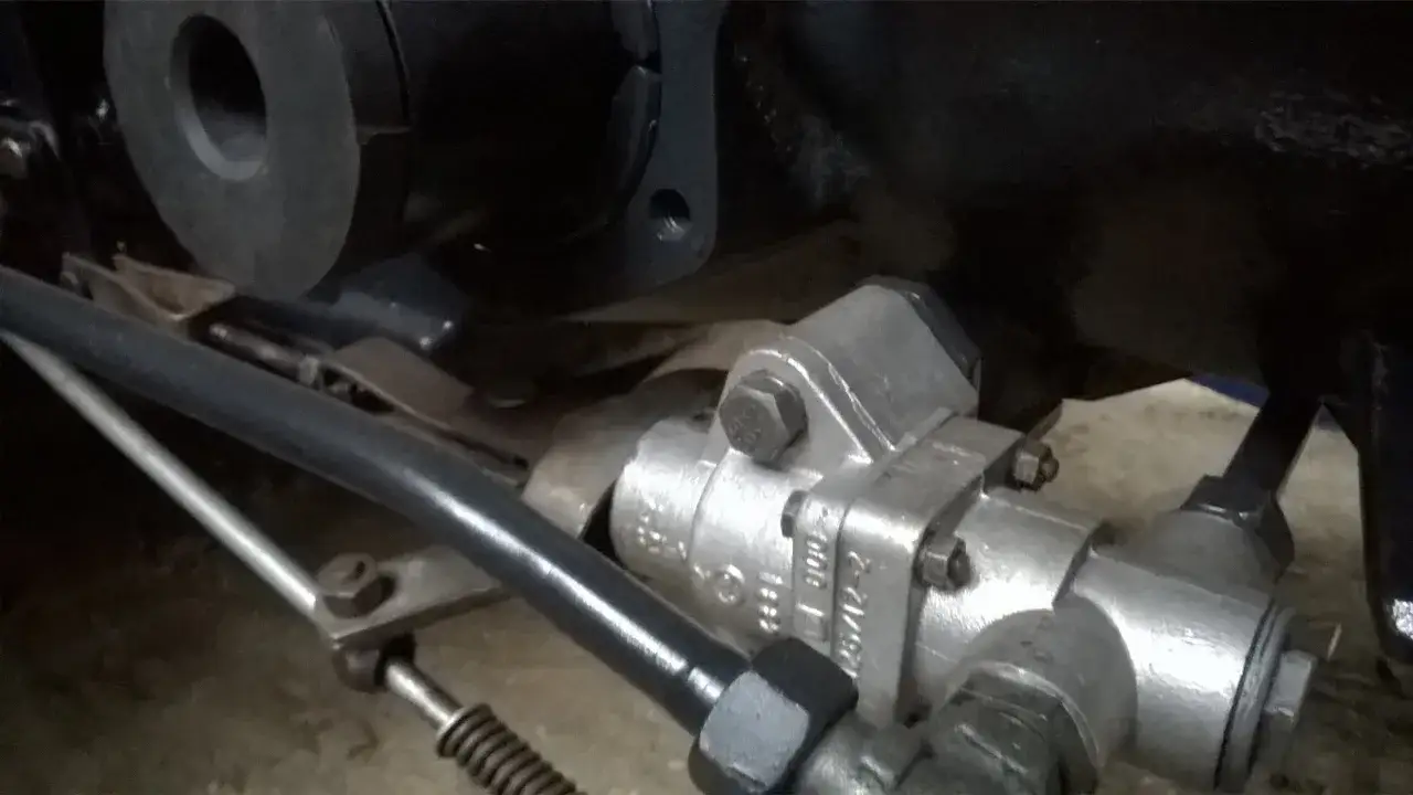Metalowy wyr&oacute;wnywacz ciśnienia Zetor, element układu hydraulicznego, zamontowany na ciągniku.