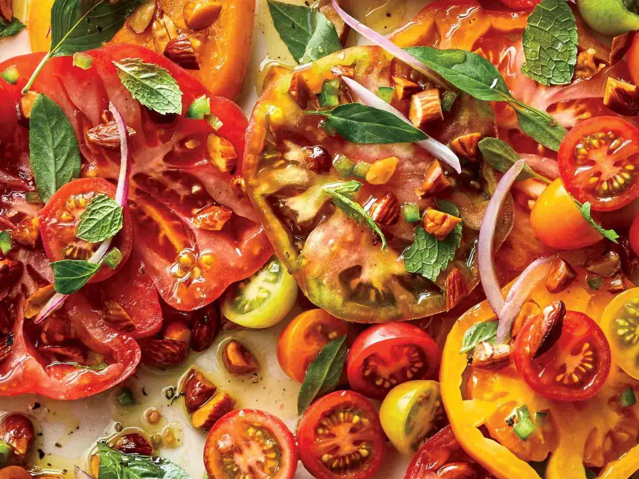 Bunter Tomatensalat mit frischer Minze, roten Zwiebeln und Mandeln, übergossen mit einem köstlichen Tomatensalat Dressing.