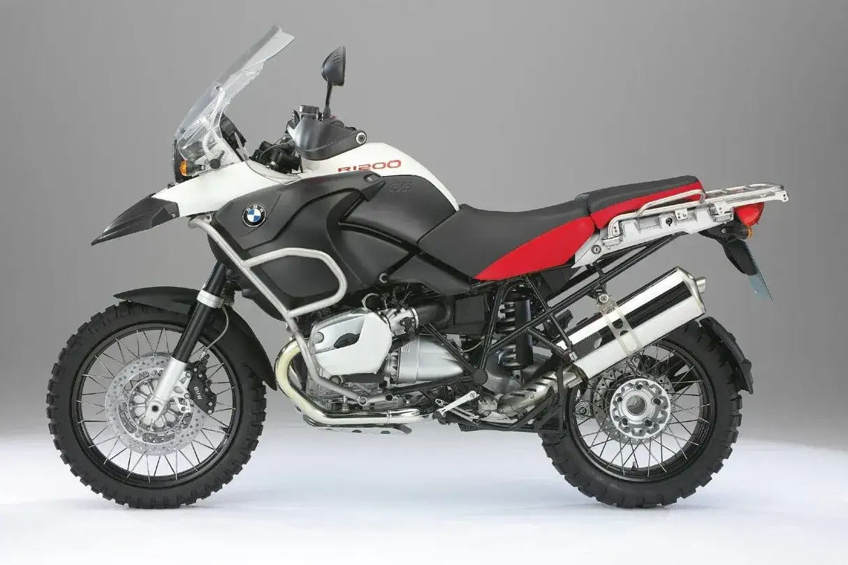 Biało-czarny motocykl BMW R1200S z czerwonym siedzeniem, gotowy na przygodę.