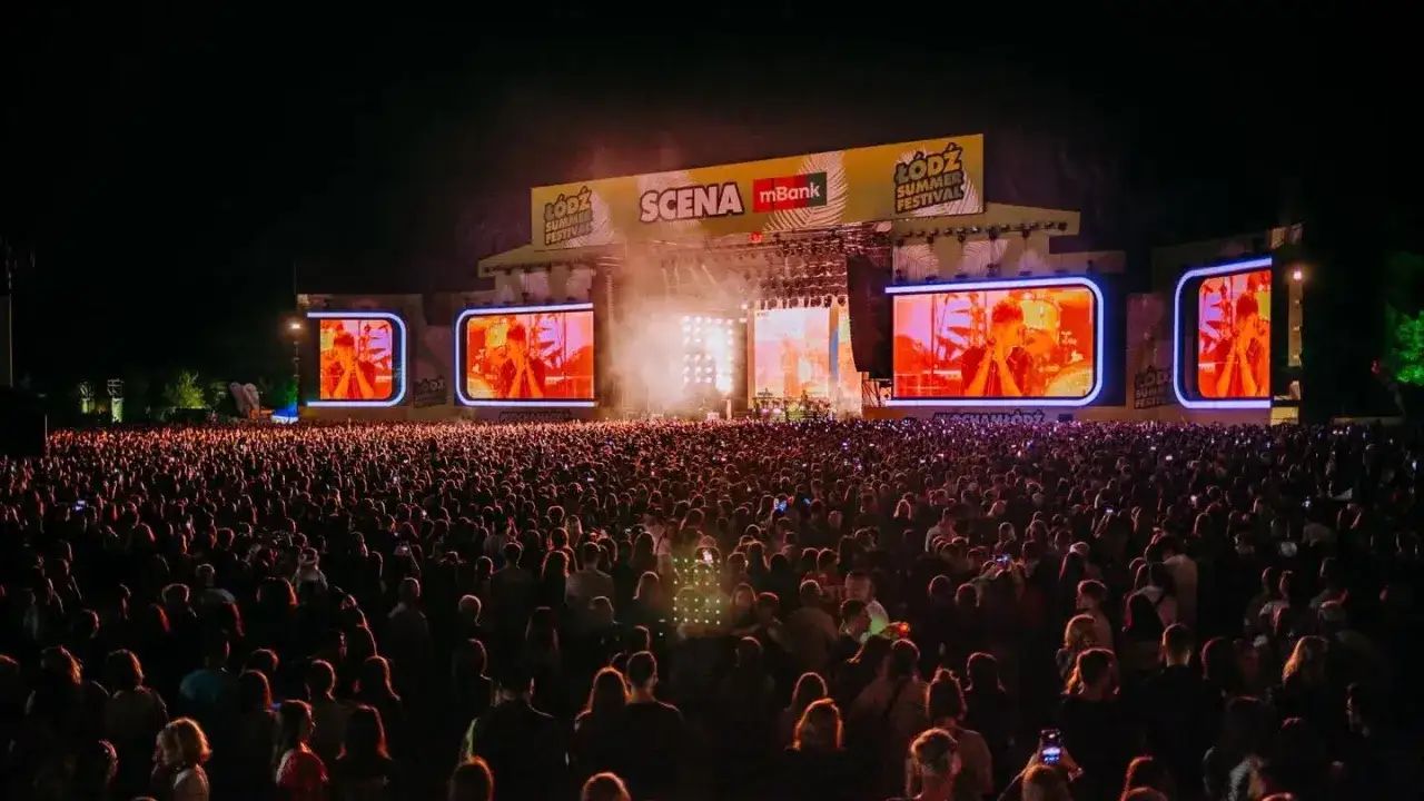 Tłum ludzi na koncercie podczas Łódź Summer Festival 2026. Na scenie artyści, a obok wielkie ekrany z ich wizerunkami.