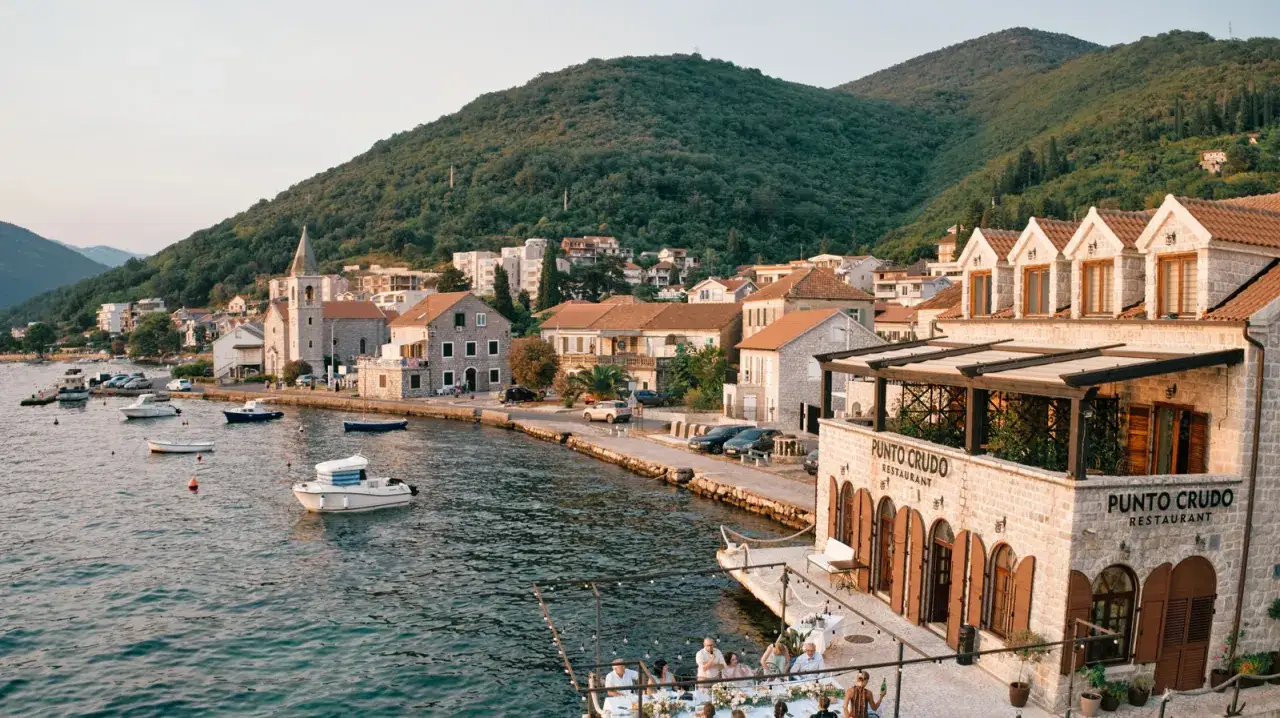 En vacker solsemester i Montenegro. En pittoresk kuststad med båtar i vattnet och en restaurang vid havet.