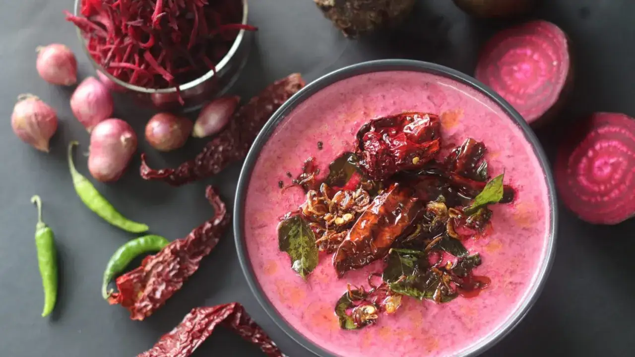 Rote Bete Suppe mit Kokosmilch und Orangensaft, garniert mit getrockneten Chilis und Curryblättern. Daneben liegen frische Rote Bete, Schalotten und grüne Chilis.