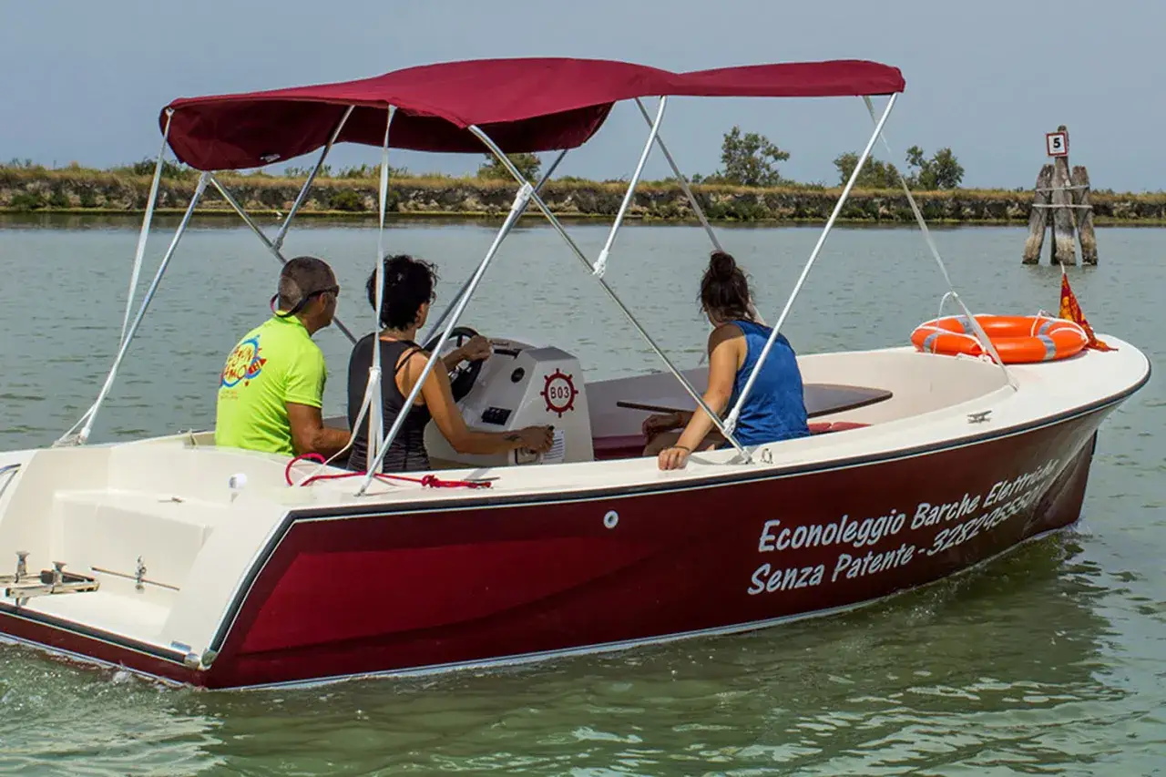 Un barchino a Venezia con tre persone a bordo, godendosi una gita sull'acqua.