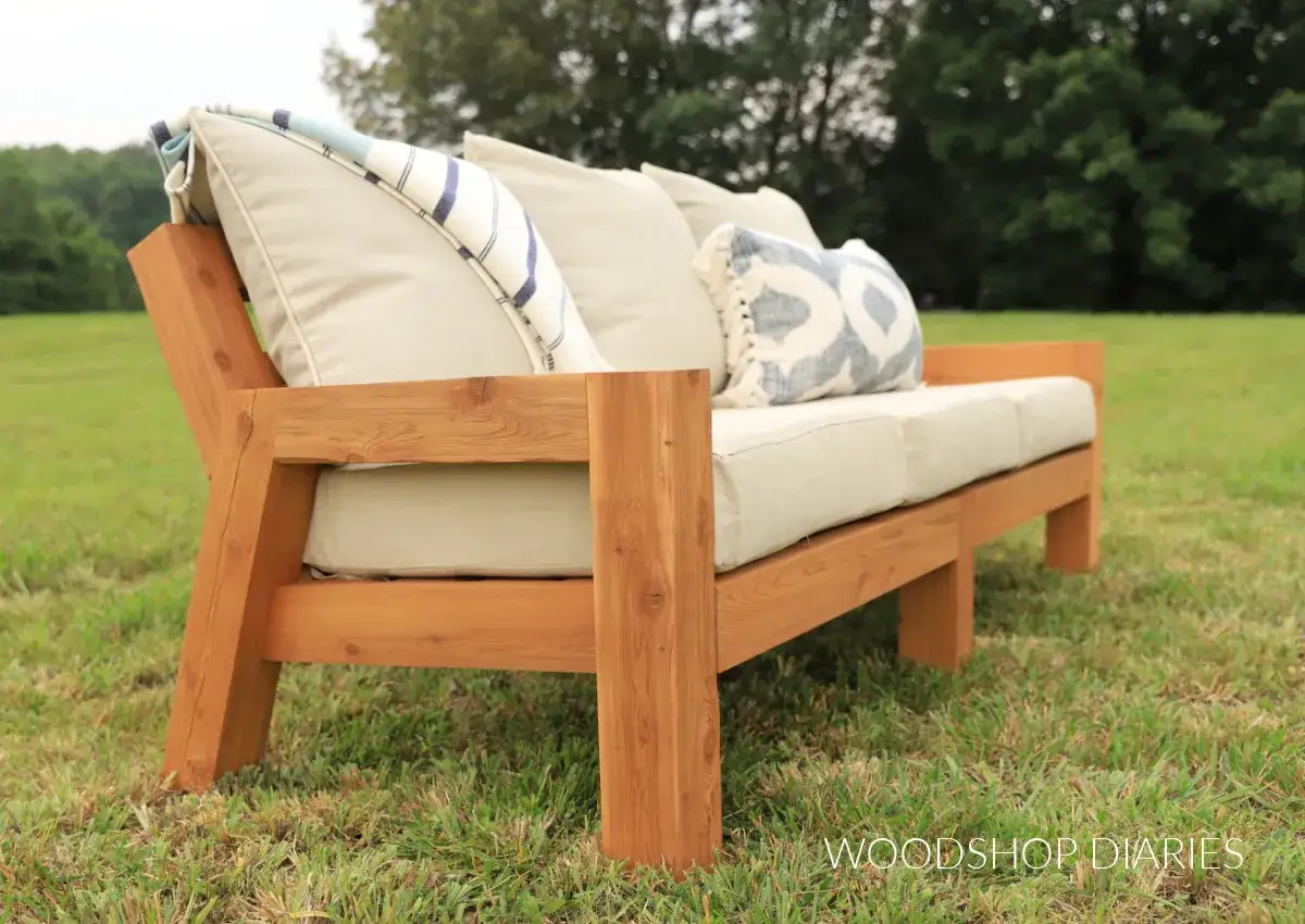 Ein gem&uuml;tliches Waldsofa, das man selber bauen kann, steht im Gr&uuml;nen. Kissen laden zum Entspannen ein.