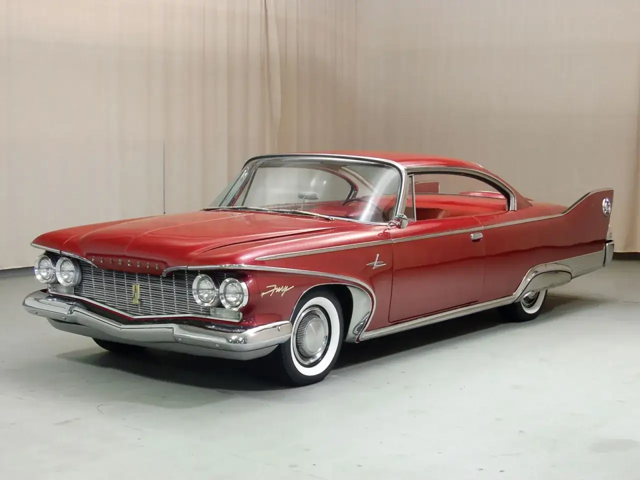R&ouml;d Plymouth Fury 1960 med eleganta fenor och kromdetaljer. En klassisk amerikansk bil.
