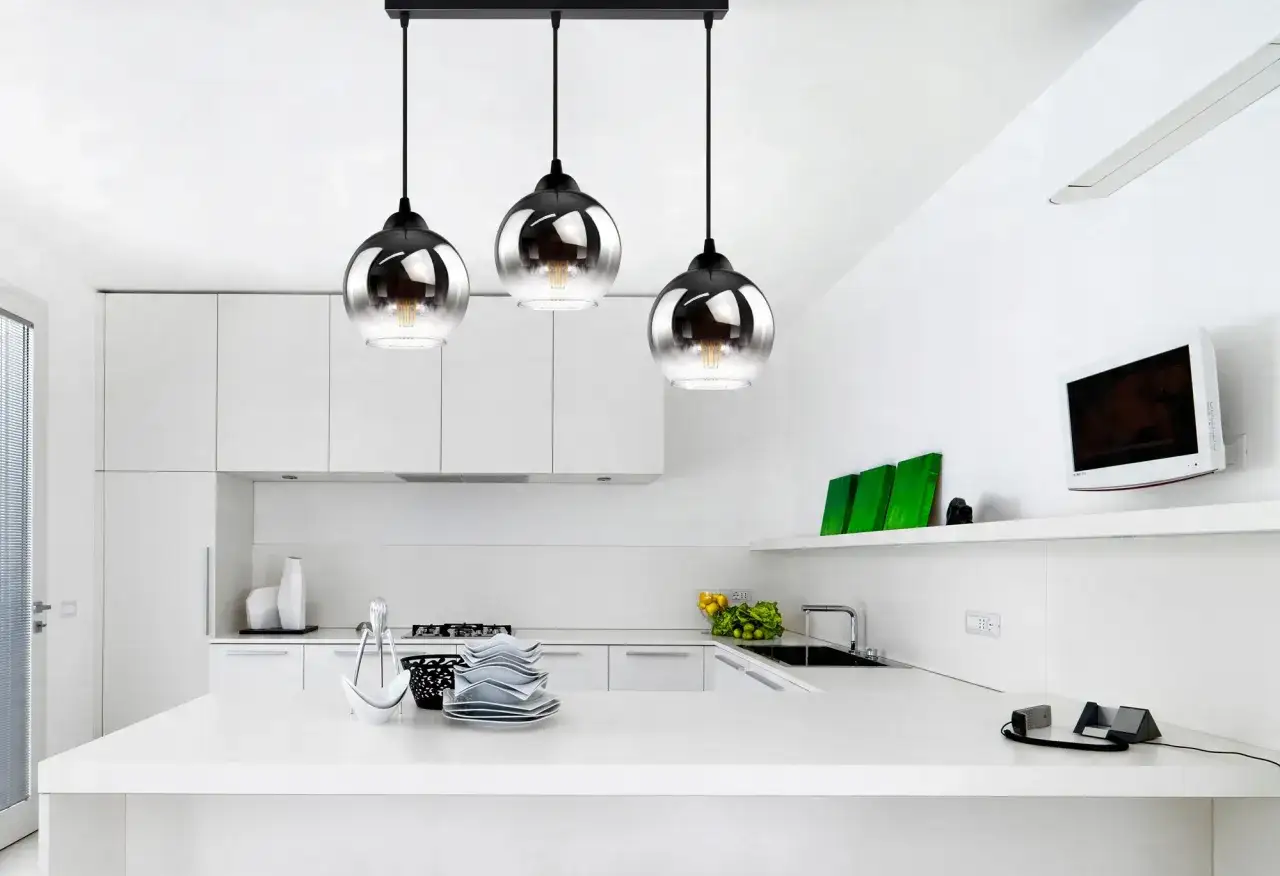 Nowoczesna kuchnia z wyspą, na której stoi elegancka lampa wisząca 3 kule.
