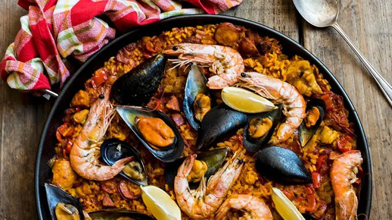 Paella mar y monta&ntilde;a, un fest&iacute;n de arroz con gambas, mejillones y trozos de chorizo.
