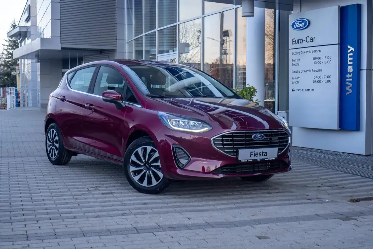 Elegancka, bordowa Fiesta MK8 zaparkowana przed salonem Forda.