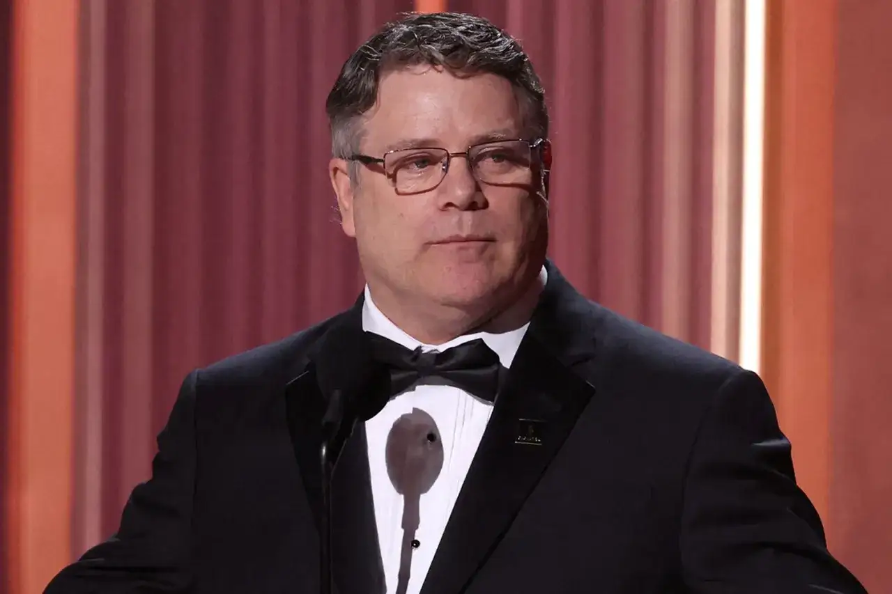 Sean Astin w garniturze z muszką, przypominający o jego bogatej karierze w filmach, serialach i programach.