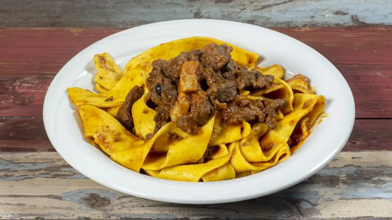 Pappardelle con rag&ugrave; di cinghiale, un piatto ricco e saporito che evoca la tradizione culinaria italiana.