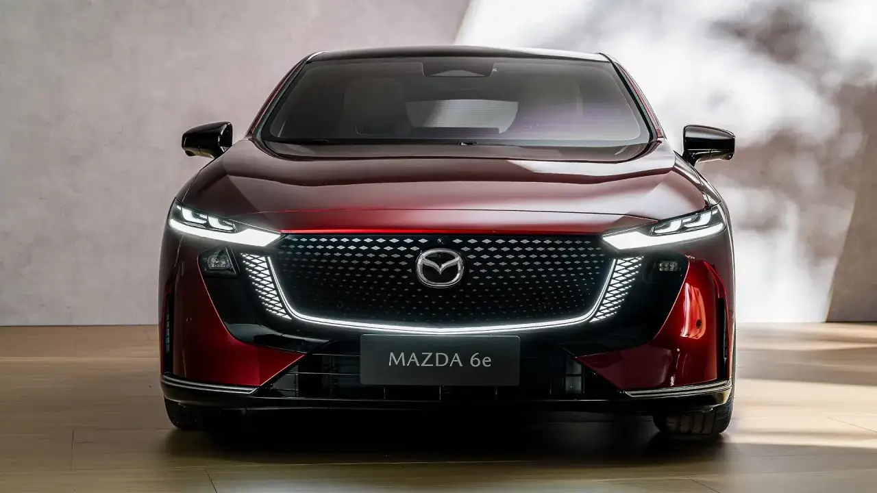 Elegancka, czerwona mazda elektryczna 6e z charakterystycznym grillem i nowoczesnymi światłami LED.