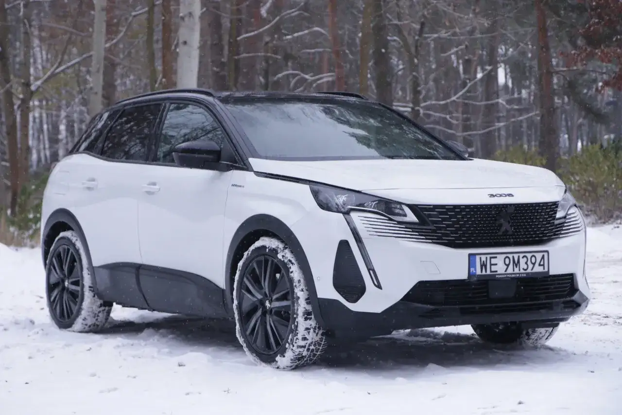 Biały Peugeot 3008 hybryda na śniegu, gotowy na zimowe wyzwania.