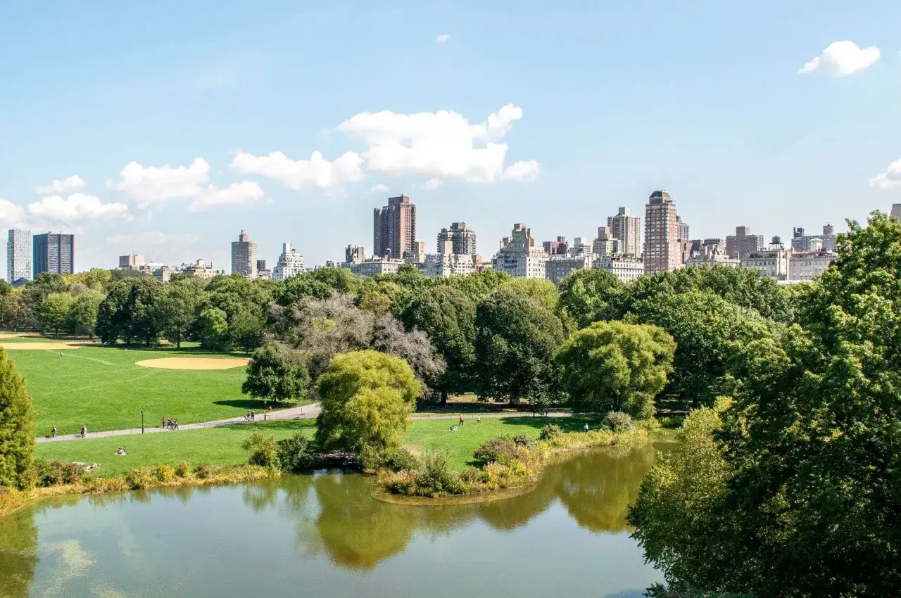 Central Park w Nowym Jorku, idealne miejsce na zwiedzanie miasta. Jezioro, zieleń i drapacze chmur w tle.
