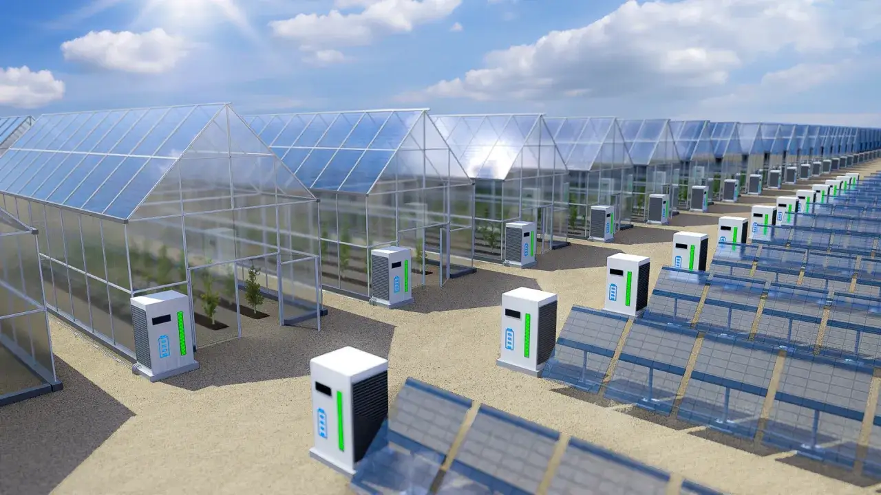 Reihe von Gew&auml;chsh&auml;usern mit organischen PV-Modulen auf den D&auml;chern und Batteriestationen davor.